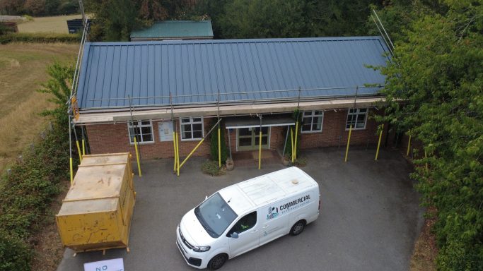 New insulated metal roof installed after asbestos roof removal on village hall