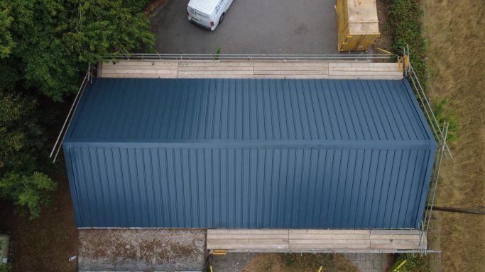 New insulated metal roof installed after asbestos roof removal on village hall
