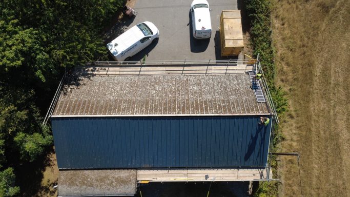 New insulated metal roof installed after asbestos roof removal on village hall