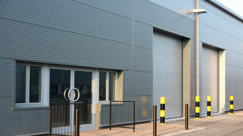 Modern industrial unit with grey cladding, glazed entrance and roller doors